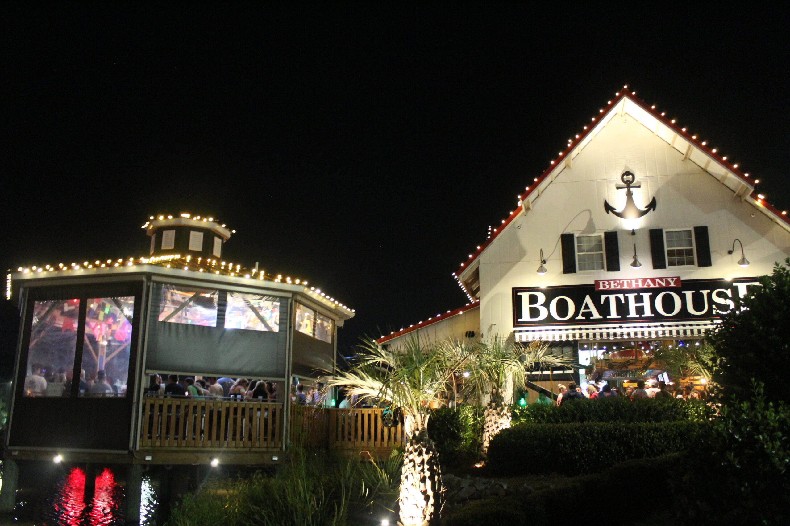 the boathouse is lit up with christmas lights