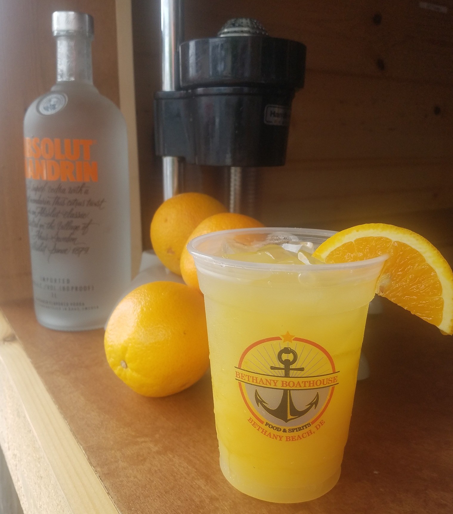 a glass of lemonade next to some oranges