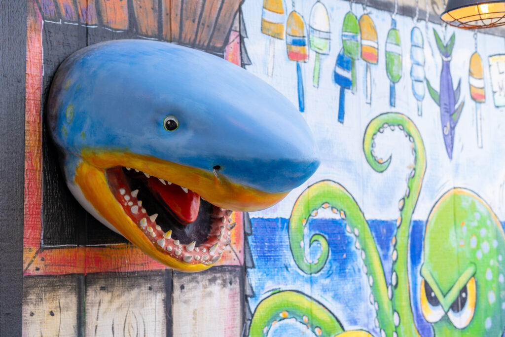 a fake shark head mounted to the side of a building