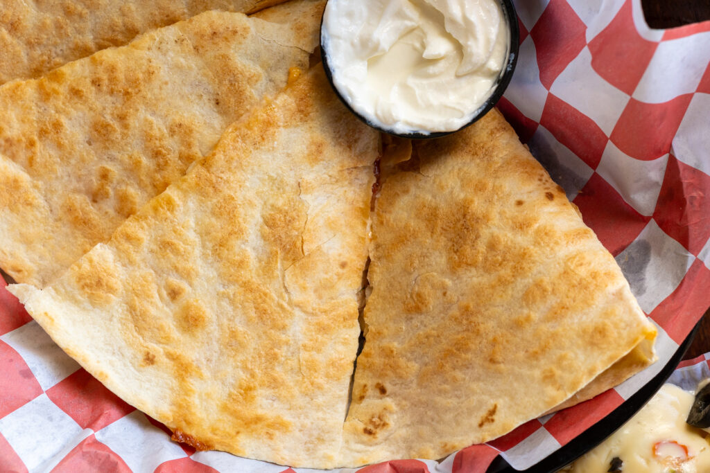 two quesadillas on a red and white checkered paper