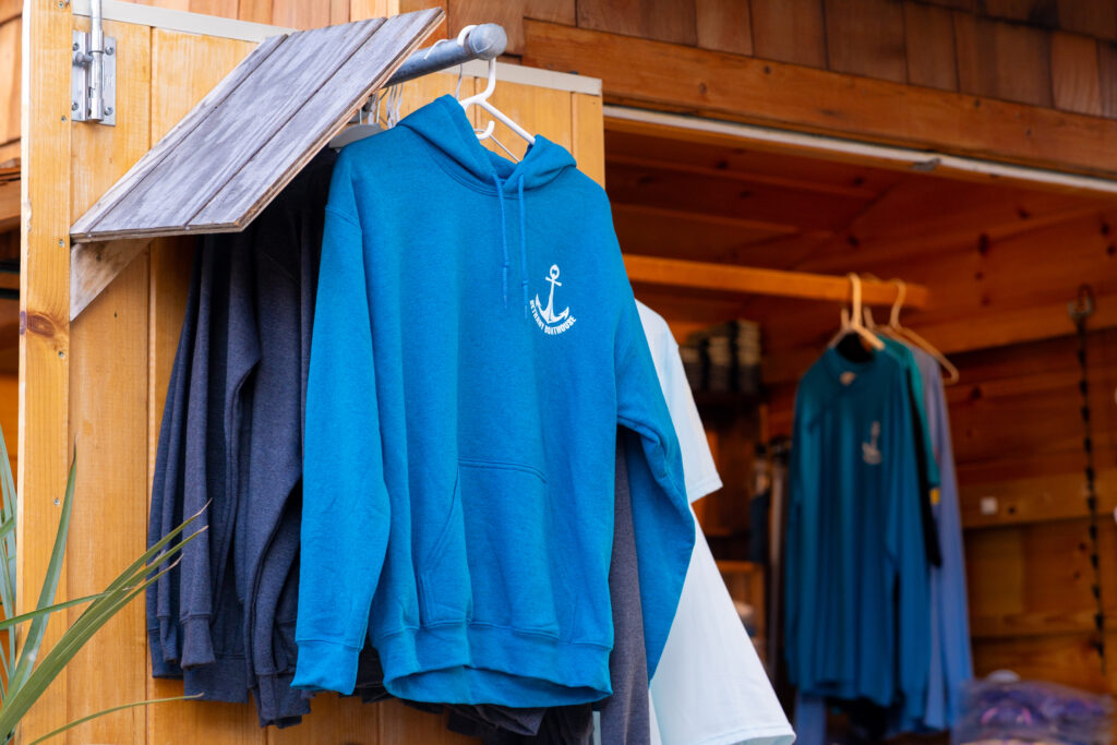 a blue sweatshirt hanging on a clothes rack